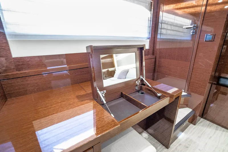 Slide: The Image of Luxurious wooden vanity area inside a 2018 Prestige 630 yacht cabin. - 66