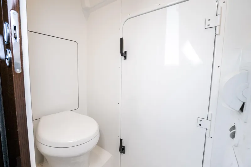 Slide: The Image of Compact bathroom in 2018 Prestige 630 yacht, featuring a sleek white toilet and door. - 78