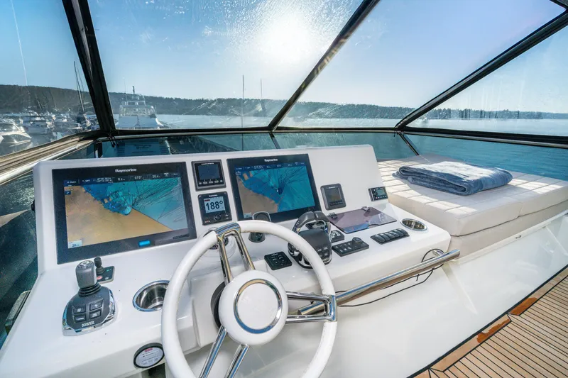 Slide: The Image of Cockpit of 2018 Prestige 630 yacht with navigation screens and sunlit view. - 8