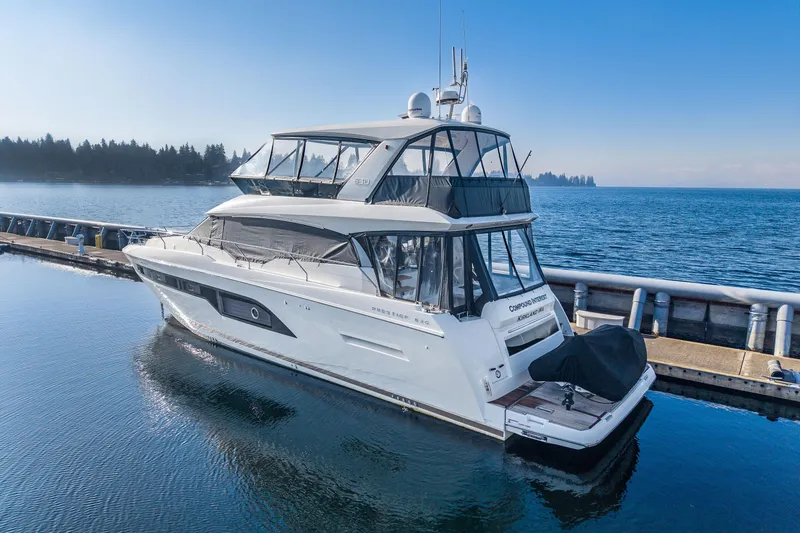 Slide: The Image of Luxury 2018 Prestige 630 yacht docked at marina, clear blue sky and water. - 91