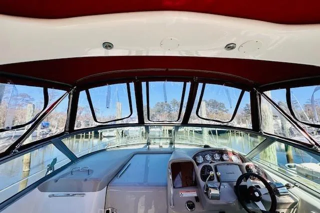 Slide: The Image of 2006 Sea Ray 340 Sundancer helm with red canopy, docked in a marina. - 15