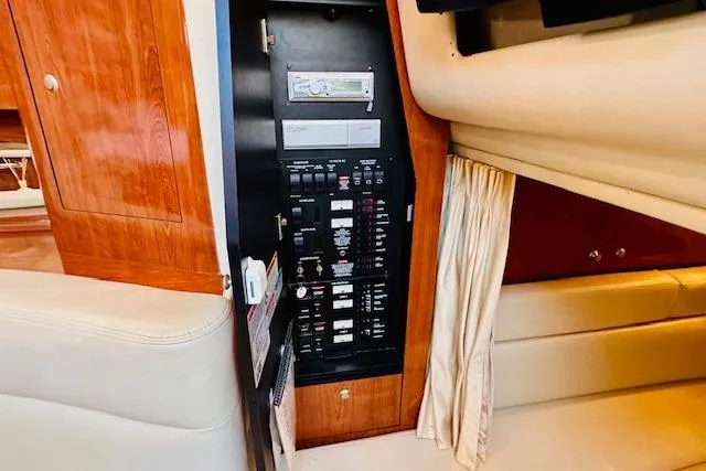 Slide: The Image of Electrical panel inside 2006 Sea Ray 340 Sundancer yacht, featuring wood cabinetry and seating. - 19