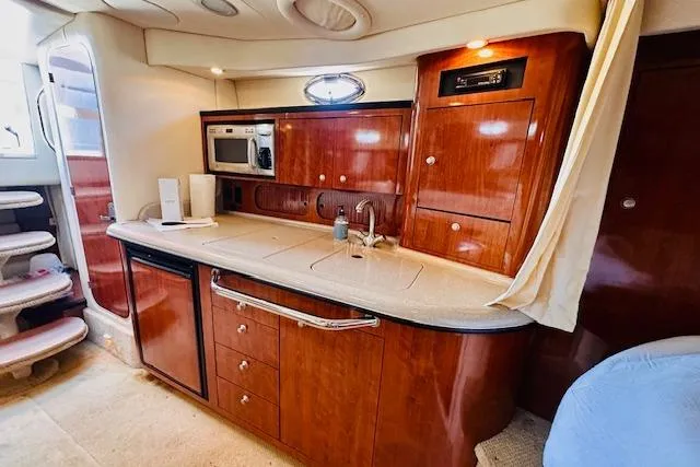 Slide: The Image of Luxurious 2006 Sea Ray 340 Sundancer yacht interior with elegant wood cabinetry and modern amenities. - 28