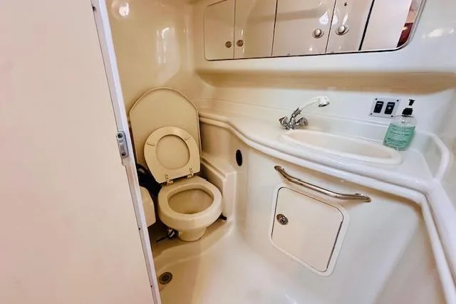 Slide: The Image of 2006 Sea Ray 340 Sundancer bathroom with toilet, sink, and storage cabinets. - 30