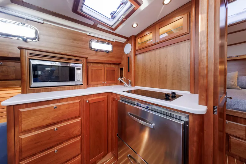 Slide: The Image of Luxurious 2022 Sabre 38 SE yacht kitchen with wood cabinetry and modern appliances. - 16