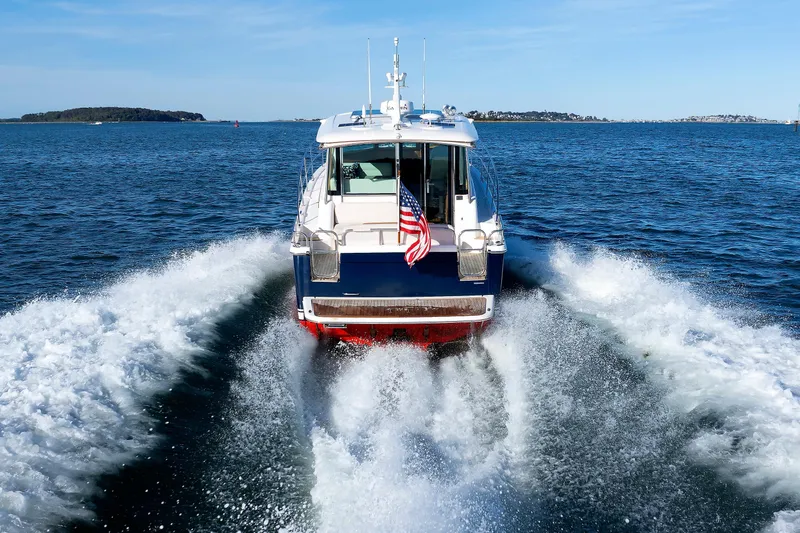Slide: The Image of 2022 Sabre 38 SE yacht cruising on open water, rear view with American flag. - 33