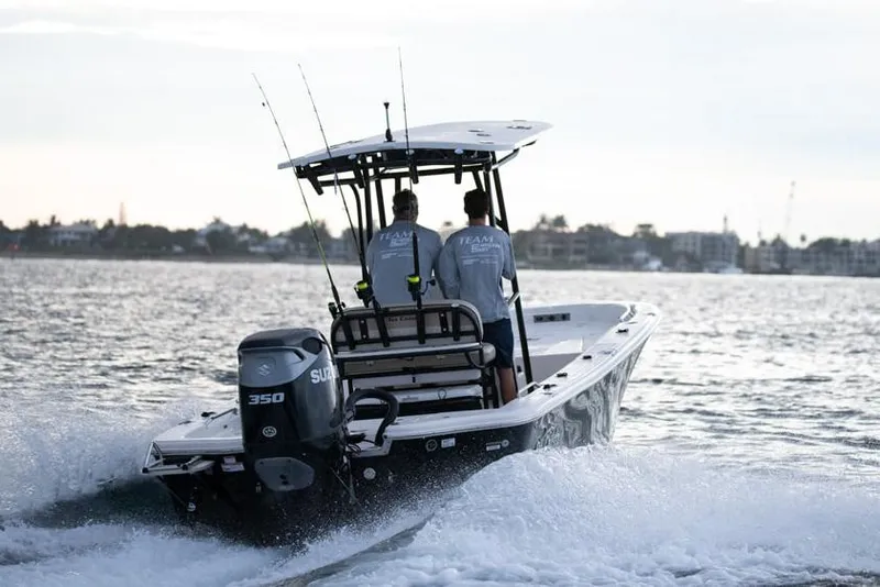 The Image of 2026 Sea Chaser 26 LX boat displayed indoors, featuring sleek design and Suzuki outboard motor. - 0