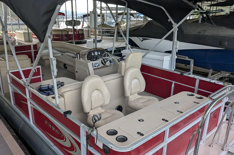 Slide: The Image of 2012 Crest CHILLER CP2 pontoon boat with beige seating and red exterior, docked in a marina. - 8
