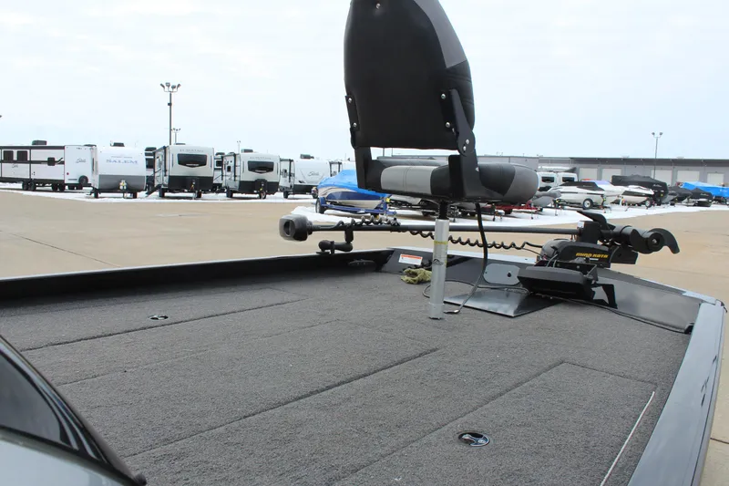 Slide: The Image of 2019 Crestliner VT 18 boat deck with fishing seat and motor, parked near RVs. - 12