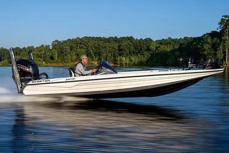 Slide: The Image of Manufacturer Provided Image: 2026 Skeeter FXR20 FLEX boat speeding on a lake with a driver, surrounded by trees. - 13