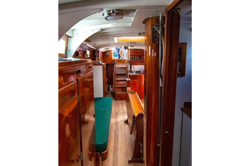 Slide: The Image of Interior of a 1957 Sparkman & Stephens K/CB Yawl, featuring polished wood and green seating. - 11