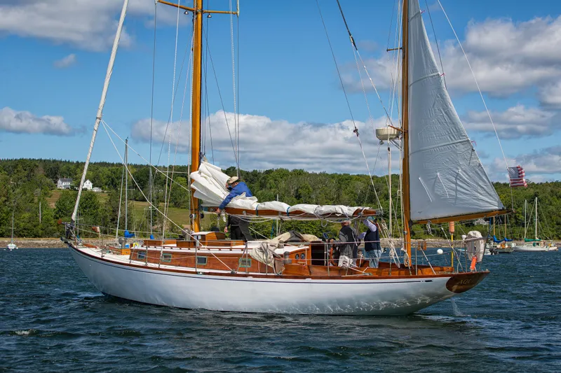 Slide: The Image of 1957 Sparkman & Stephens K/CB Yawl sailing on a scenic lake under blue skies. - 39