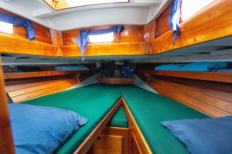 Slide: The Image of 1957 Sparkman & Stephens K/CB Yawl interior with wooden finish and green cushions. - 7