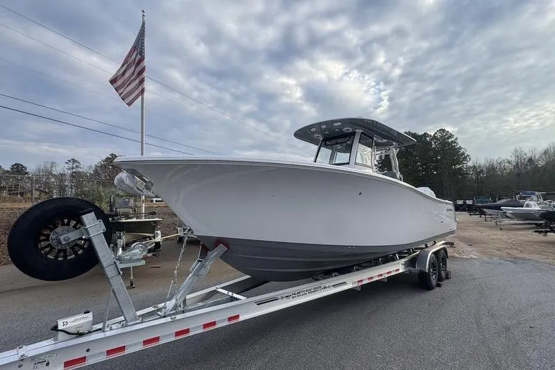 The Image of 2026 Sportsman Open 282 Center Console boat on trailer under cloudy sky. - 1