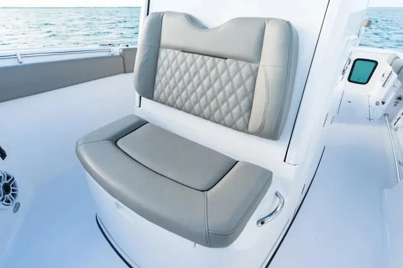 Slide: The Image of 2026 Sportsman Open 282 Center Console boat with luxurious seating and ocean backdrop. - 13