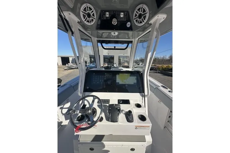Slide: The Image of 2026 Sportsman Open 282 Center Console boat dashboard with steering wheel and navigation screens. - 38