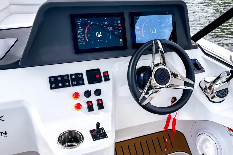 Slide: The Image of Modern STERK 31 boat dashboard with dual screens and sleek steering wheel, 2025 model. - 11