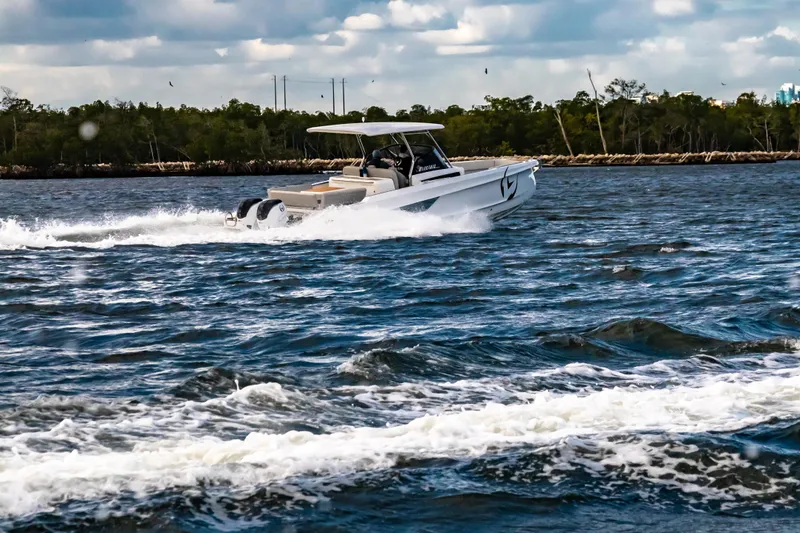 Slide: The Image of 2025 STERK 31 boat cruising on a scenic waterway under a cloudy sky. - 21