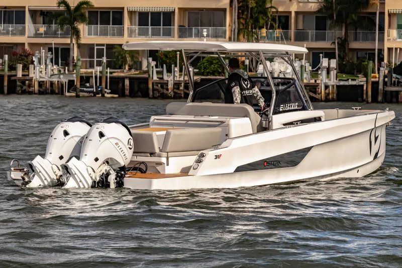Slide: The Image of Electric STERK 31 boat cruising near waterfront homes, 2025 model. - 3