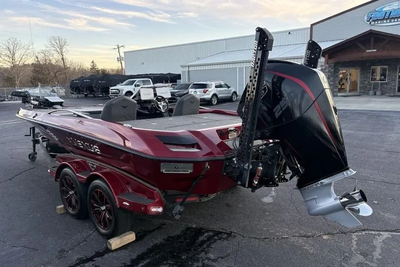 Slide: The Image of 2021 Vexus VX20 boat with powerful outboard motor, parked outside a marine dealership. - 13