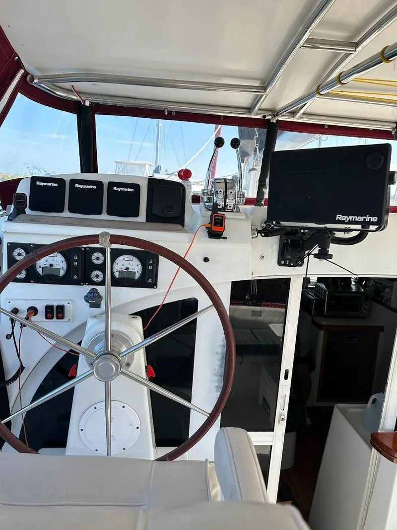 Slide: The Image of Interior view of a 2004 Lagoon 380 catamaran cockpit with navigation equipment and steering wheel. - 12