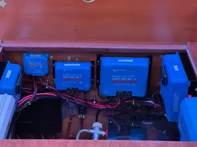 Slide: The Image of Electrical system components inside a 2004 Lagoon 380 catamaran, featuring MPPT controllers and wiring. - 23