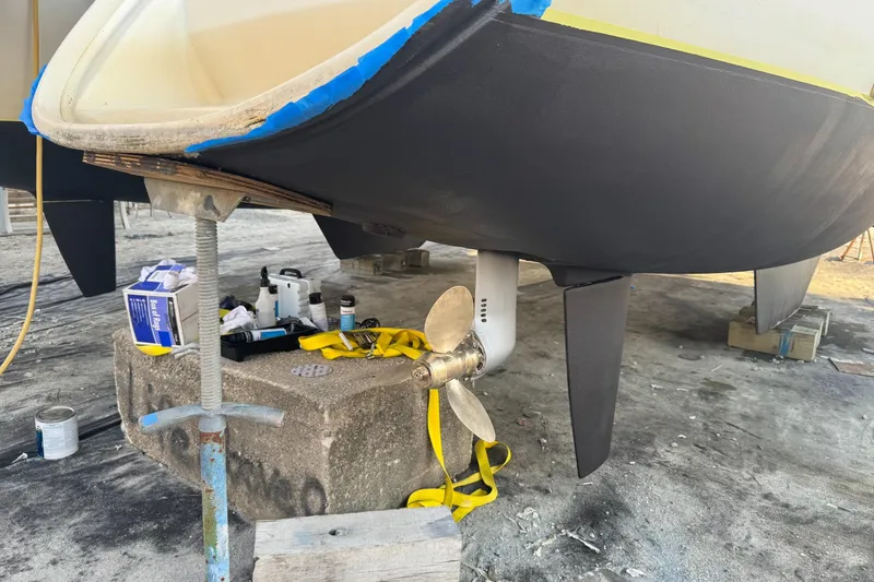 Slide: The Image of 2004 Lagoon 380 catamaran under maintenance, showing propeller and hull details. - 5