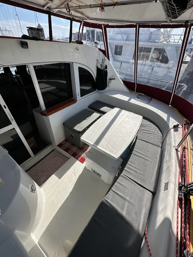 Slide: The Image of Lagoon 380 catamaran interior, 2004 model, featuring a spacious seating area with a table. - 9