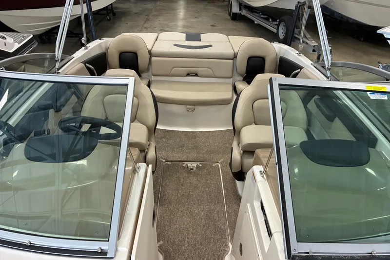 Slide: The Image of 2017 Chaparral 21 H2O Ski & Fish boat interior with beige seating and windshield. - 11