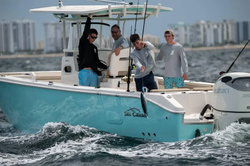 Slide: The Image of 2026 Sea Chaser 30 HFC CC boat with Suzuki engine, displayed indoors. - 4