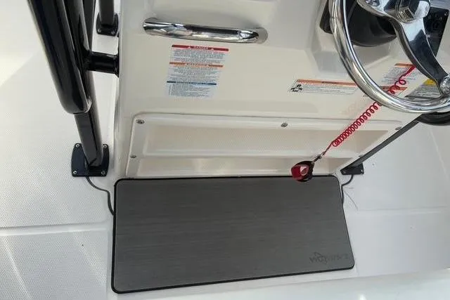 Slide: The Image of Robalo R222 Center Console 2023 helm area with steering wheel and safety lanyard. - 13