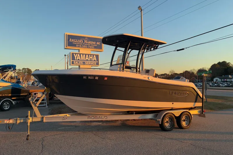 The Image of 2023 Robalo R222 Center Console boat on trailer at sunset. - 1
