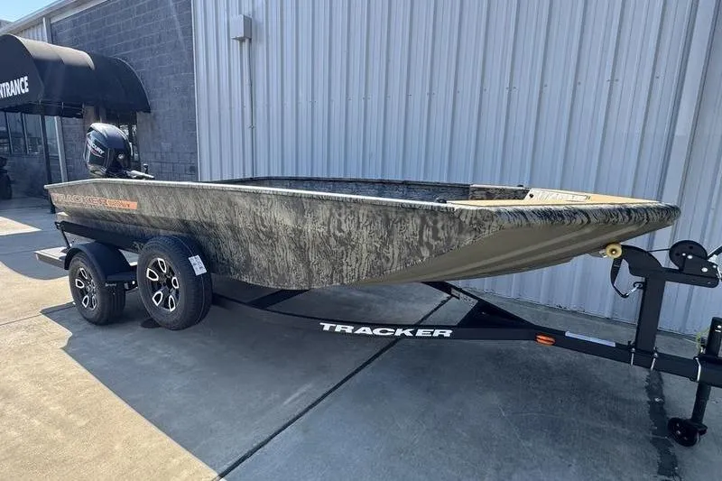 Slide: The Image of 2026 Tracker Grizzly 1756 T Marsh boat on trailer, parked outside a building. - 4