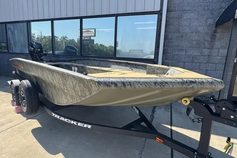 Slide: The Image of 2026 Tracker Grizzly 1756 T Marsh boat on trailer, parked outside a building. - 8