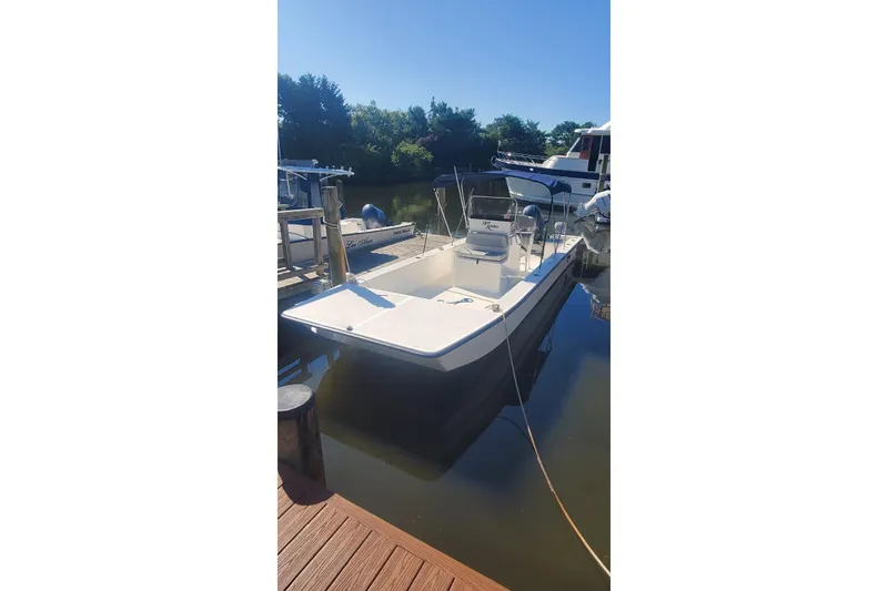 Slide: The Image of 2022 KenCraft BayRider 2460 boat docked on calm water under clear blue sky. - 0