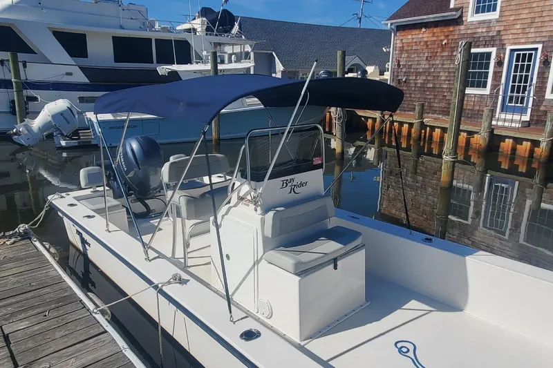 Slide: The Image of 2022 KenCraft BayRider 2460 boat docked, featuring a blue canopy and sleek design. - 6