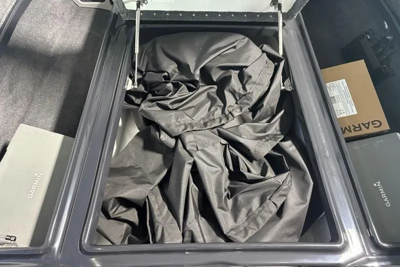 Slide: The Image of Open storage compartment in 2026 Phoenix 919 ZXL with black fabric and Garmin boxes. - 12