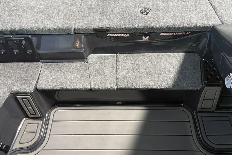 Slide: The Image of 2026 Phoenix 919 ZXL boat interior with gray carpet and storage compartments. - 14