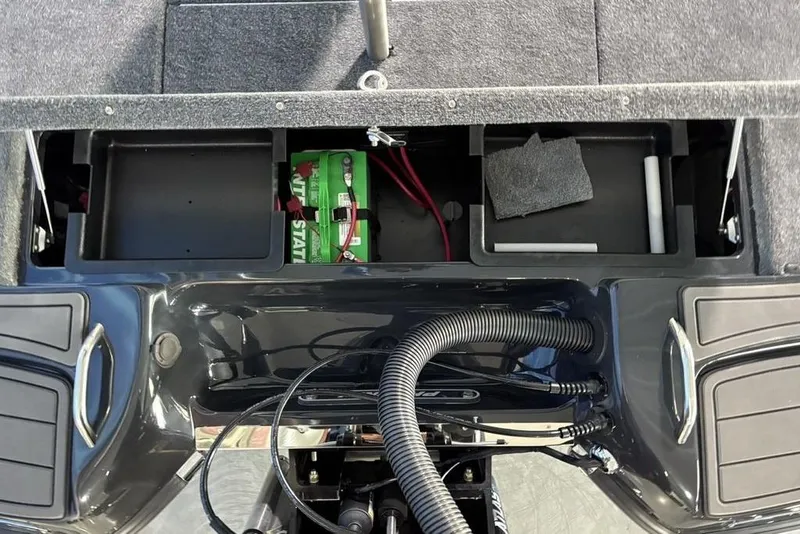 Slide: The Image of Open storage compartments in a 2026 Phoenix 919 ZXL boat, featuring a green battery. - 27