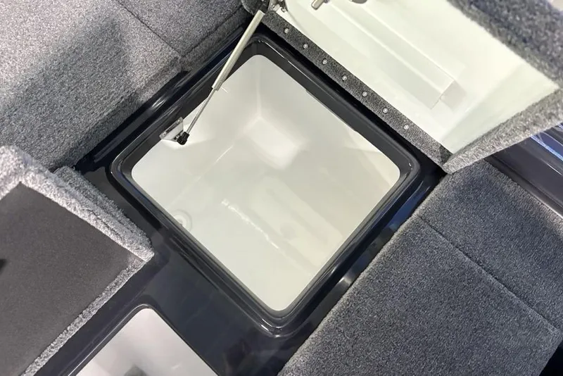 Slide: The Image of Open storage compartment in 2026 Phoenix 919 ZXL boat, featuring gray carpeted interior. - 30