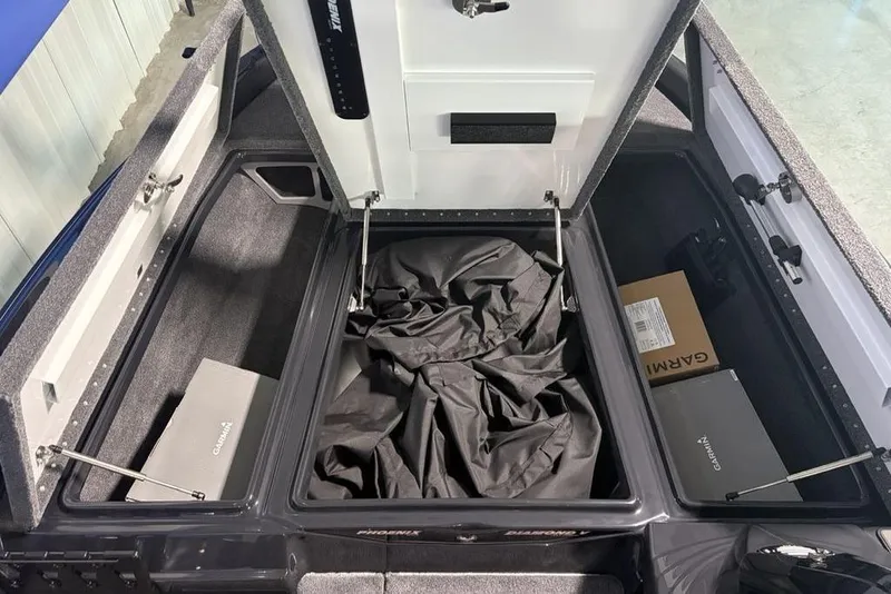 Slide: The Image of Open storage compartments in a 2026 Phoenix 919 ZXL boat, featuring Garmin equipment. - 9
