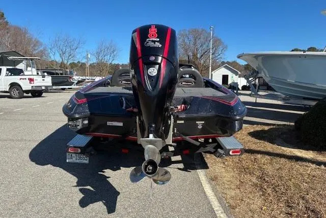 Slide: The Image of 2022 Triton 18 TrX boat with powerful outboard motor in a sunny parking lot. - 2