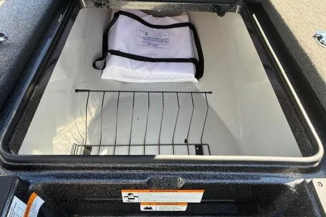 Slide: The Image of 2022 Triton 18 TrX storage compartment with white bag and wire rack inside. - 4