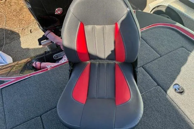 Slide: The Image of 2022 Triton 18 TrX boat seat with red and black upholstery on a gray deck. - 5