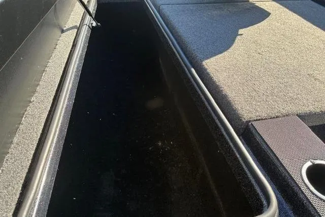 Slide: The Image of 2022 Triton 18 TrX boat storage compartment with carpeted interior. - 8