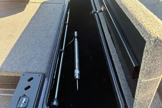 Slide: The Image of Storage compartment of 2022 Triton 18 TrX boat with fishing rod holders. - 9