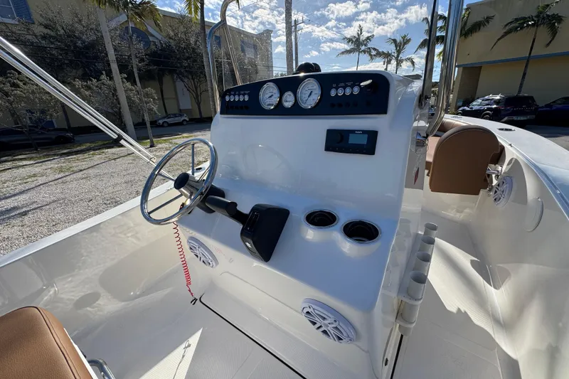 Slide: The Image of 2026 Pioneer 180 Islander boat console with steering wheel, gauges, and cup holders. - 10