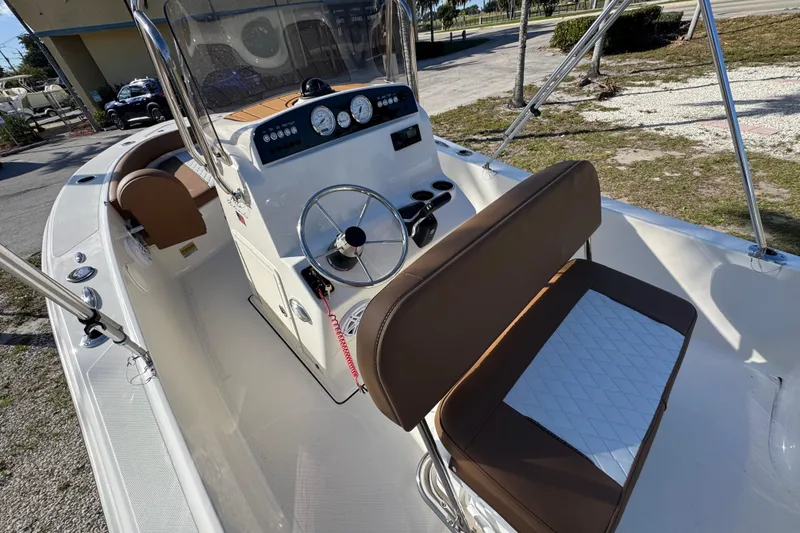 Slide: The Image of 2026 Pioneer 180 Islander boat interior with steering console and seating. - 11