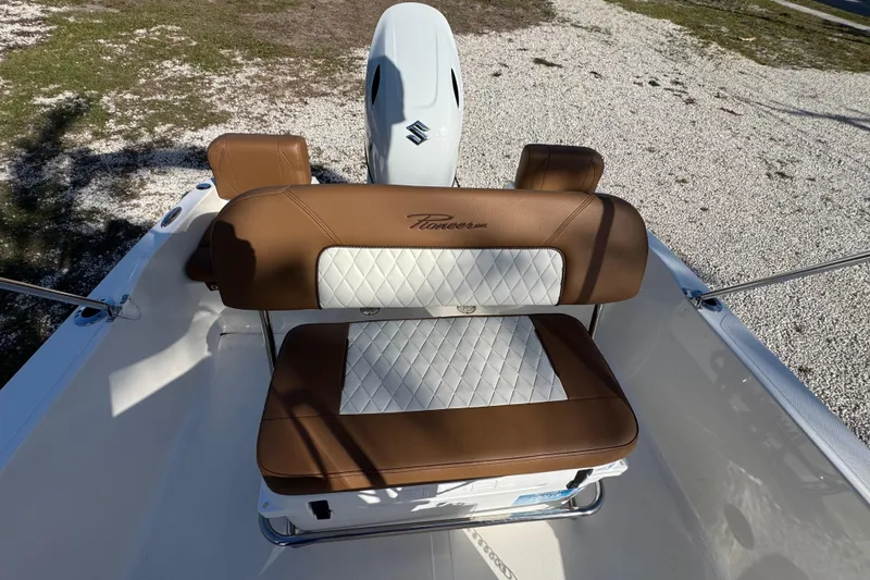 Slide: The Image of 2026 Pioneer 180 Islander boat with brown and white seating, Suzuki engine visible. - 12