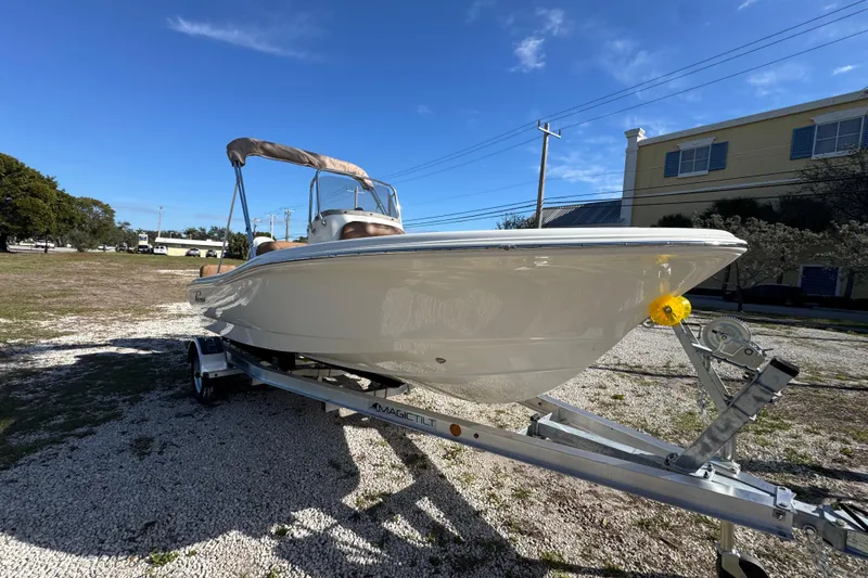 Slide: The Image of 2026 Pioneer 180 Islander boat on trailer, parked outdoors under clear blue sky. - 2